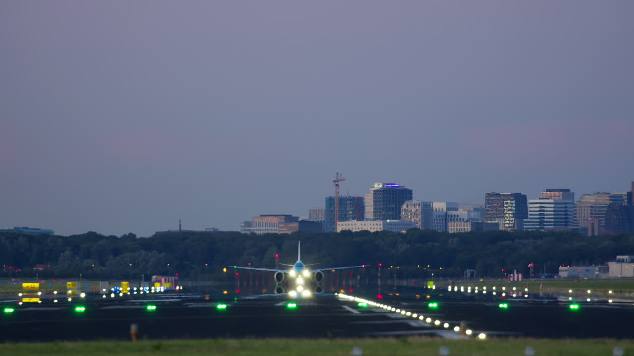 도시 스카이 라인 위 에 밤 에 착륙 하는 비행기