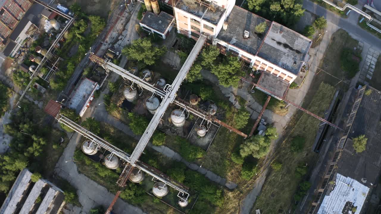 Luftfoto oppefra af rustne, forladte store containere i et industriområde