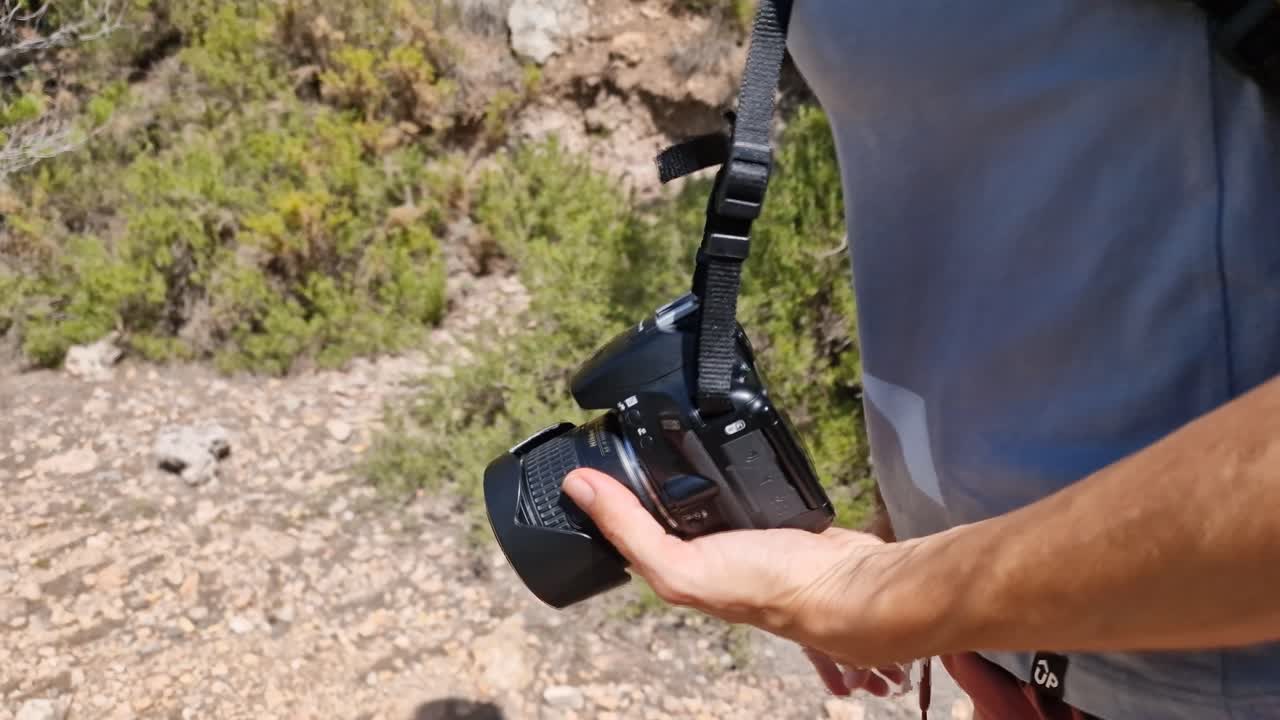 Athletic female walking in the outdoors at summer with camera in hand