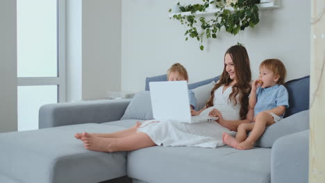 a young mother and two young sons make purchases in the online store using a laptop