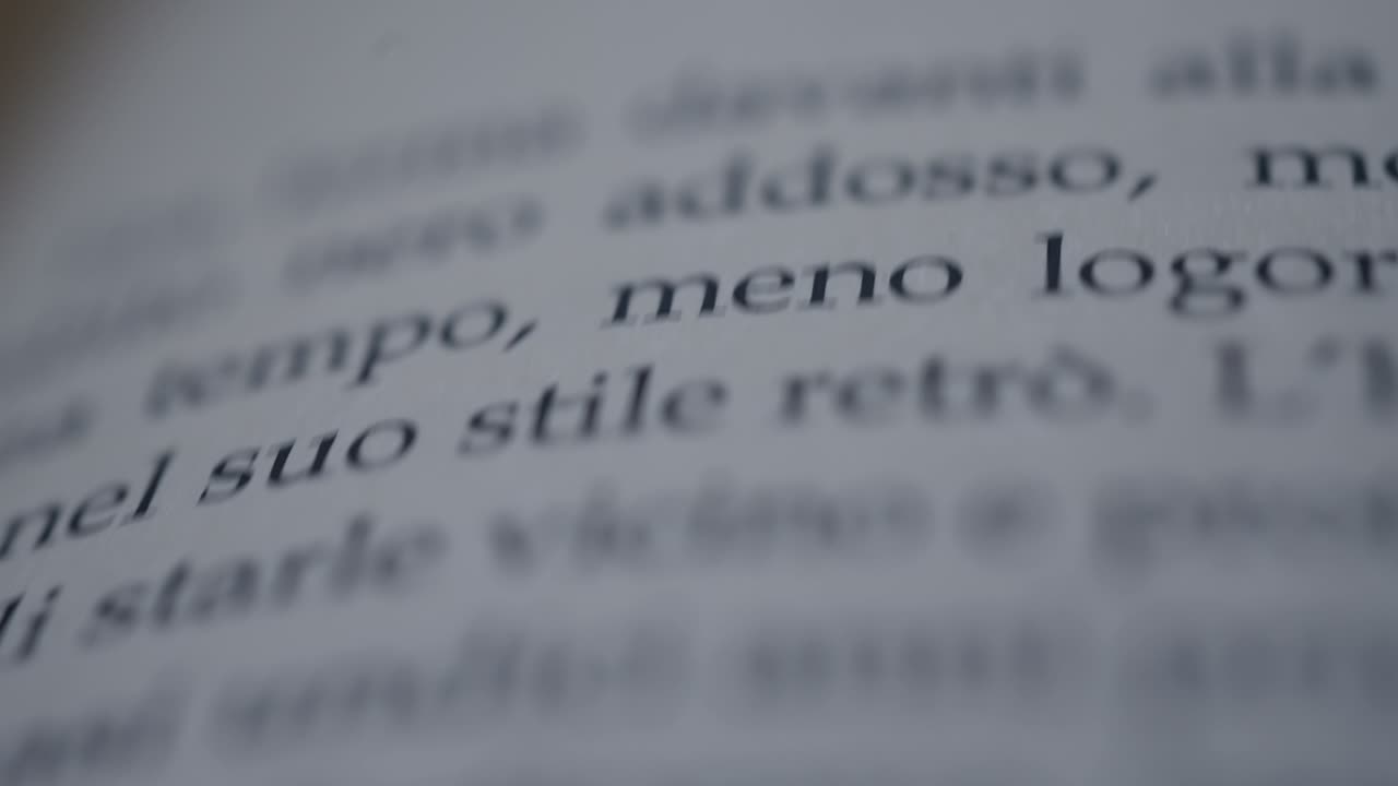 Camera scrolls across a page of an italian book slow motion macro shot
