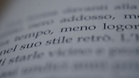 Camera-scrolls-across-a-page-of-an-italian-book-slow-motion-macro-shot