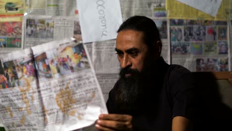 man holding burning news paper in hands