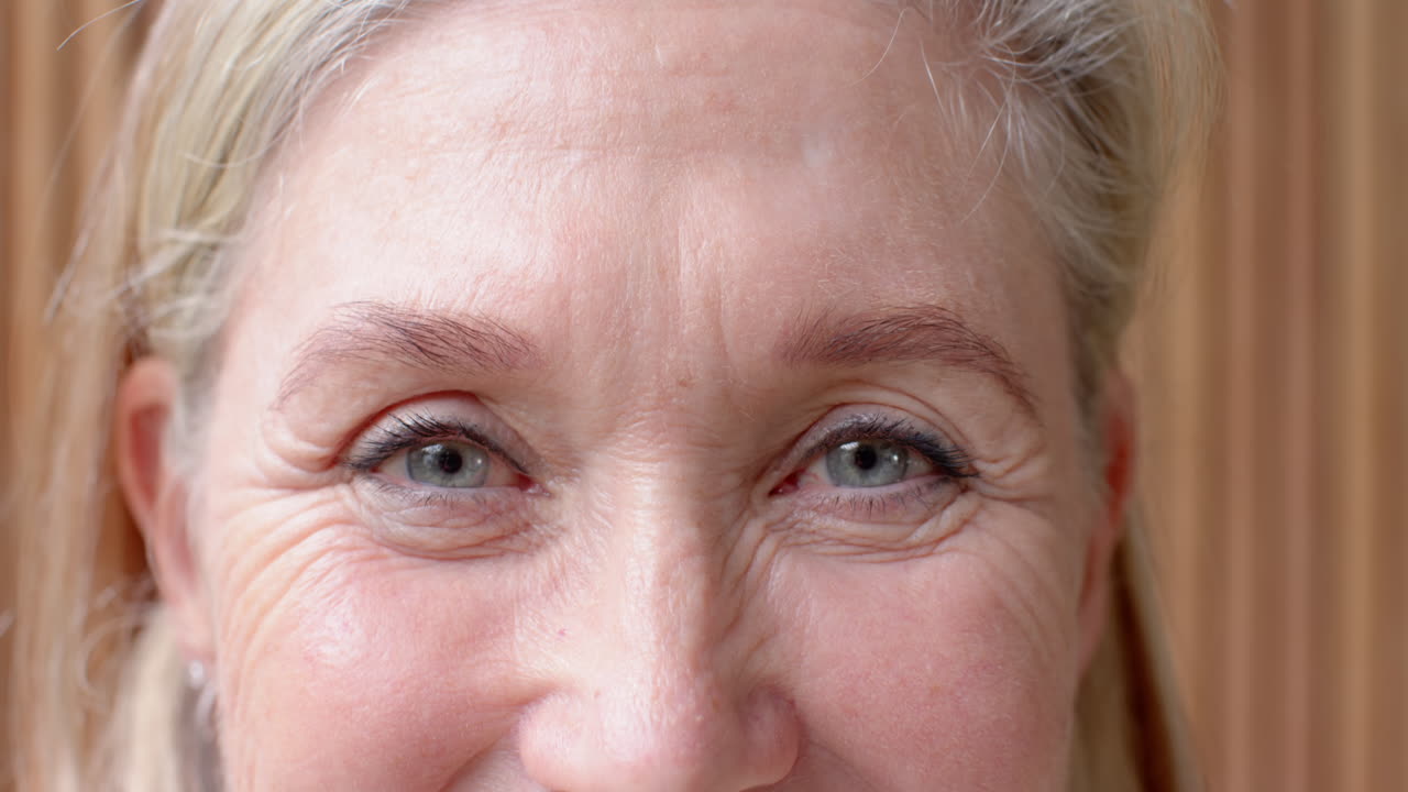 Close-up of senior woman's eyes, showing wrinkles and natural beauty, at home