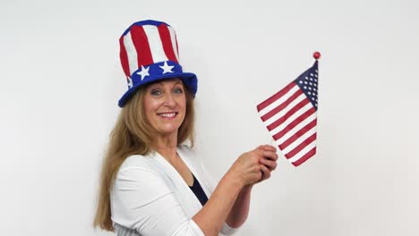 with a hat in the star and stripes, a woman sways an american flag in slow motion