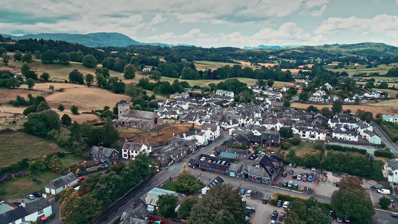 imágenes cinematográficas de drones aéreos de la aldea de hawkshead y la iglesia de san miguel y todos los ángeles