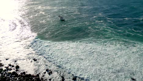 A-sailing-boat-anchored-next-to-Cook-Island-adjacent-to-Fingal-Head-in-New-South-Wales,-Australia-in-Summer