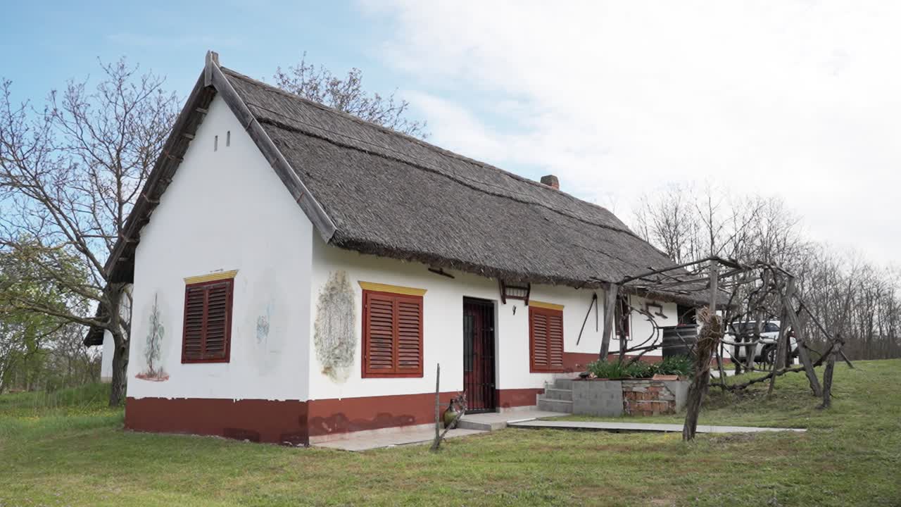 Whitewashed countryside house with thatched roof and wall paintings