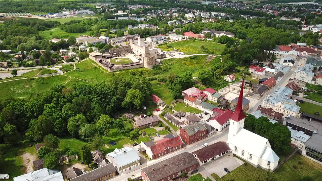 4K Luchtpanorama van Rakvere: Middeleeuwse Kasteelruïnes, Tarvas Standbeeld en Heilige Drievuldigheidskerk, Estland 2025