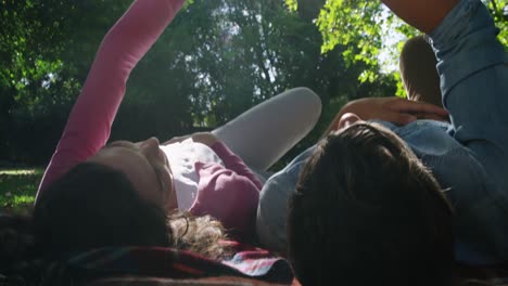 Romantic-couple-holding-hands-while-relaxing-in-park