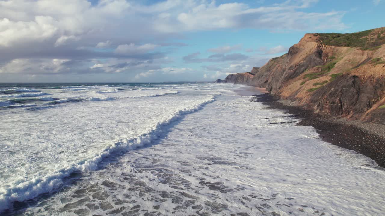 drone aéreo 4k estableciendo una toma de las ondas suaves en praia da cordoama costa de acantilado escondido cerca de la región del algarve de portugal