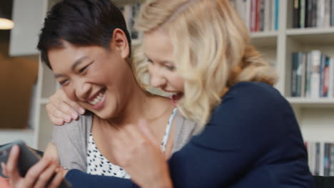 집 에서 친구 들 이 스마트 폰 을 이용 하여 웃고 즐기고 있다