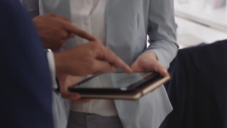 corporate business people using digital tablet computer browsing data on screen discussing project collaborating planning partnership in startup office workplace