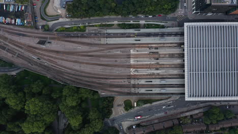 Aerial-birds-eye-overhead-top-down-view-of-long-high-speed-train-unit-leaving-St-Pancras-train-station.-London,-UK