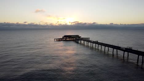 Relajante-Ondulación-Cálido-Amanecer-Océano-Trato-Muelle-Kent-Aéreo-Estático-Hito-Disparo