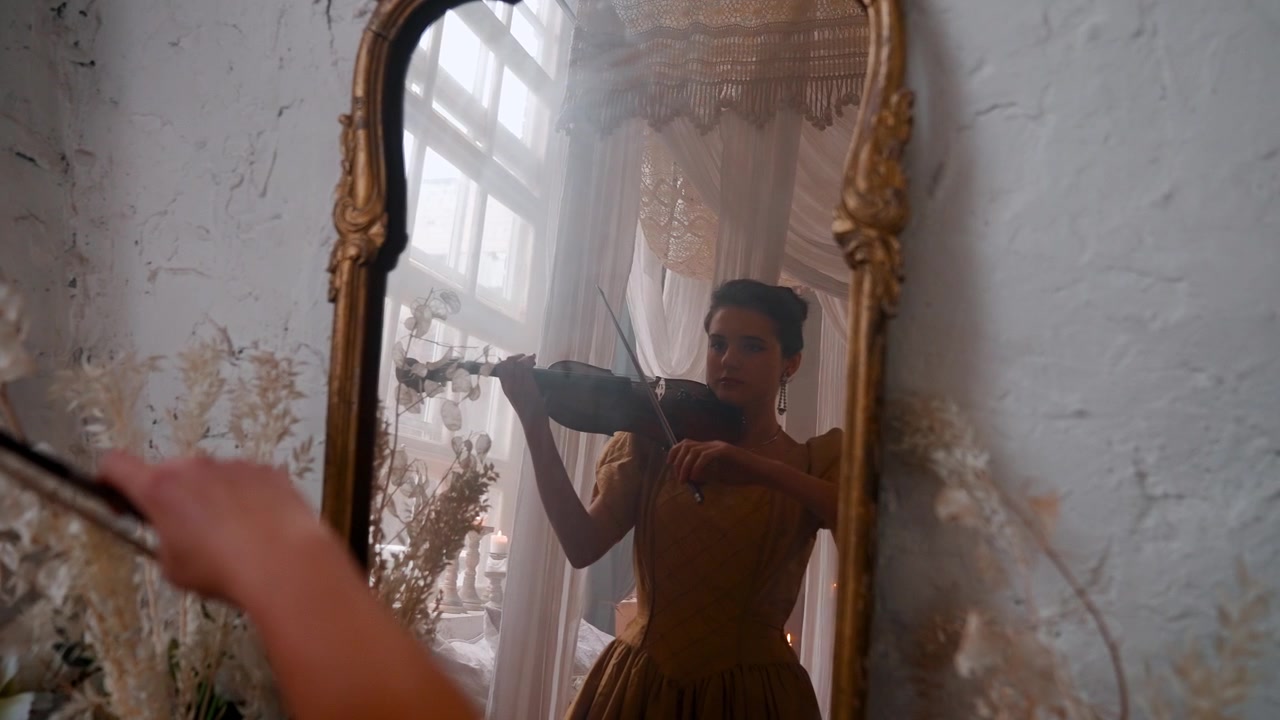 Donna elegante che suona il violino nel riflesso di uno specchio ornato