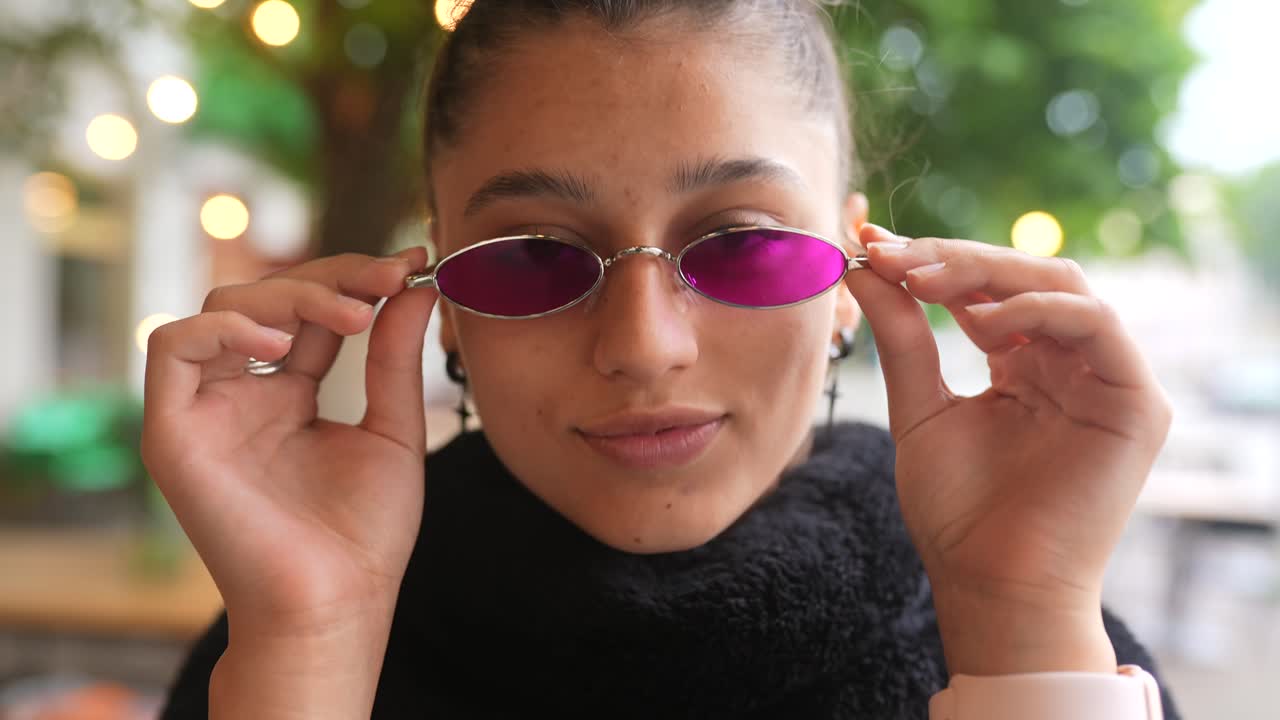 mujer joven con gafas de sol rosas al aire libre