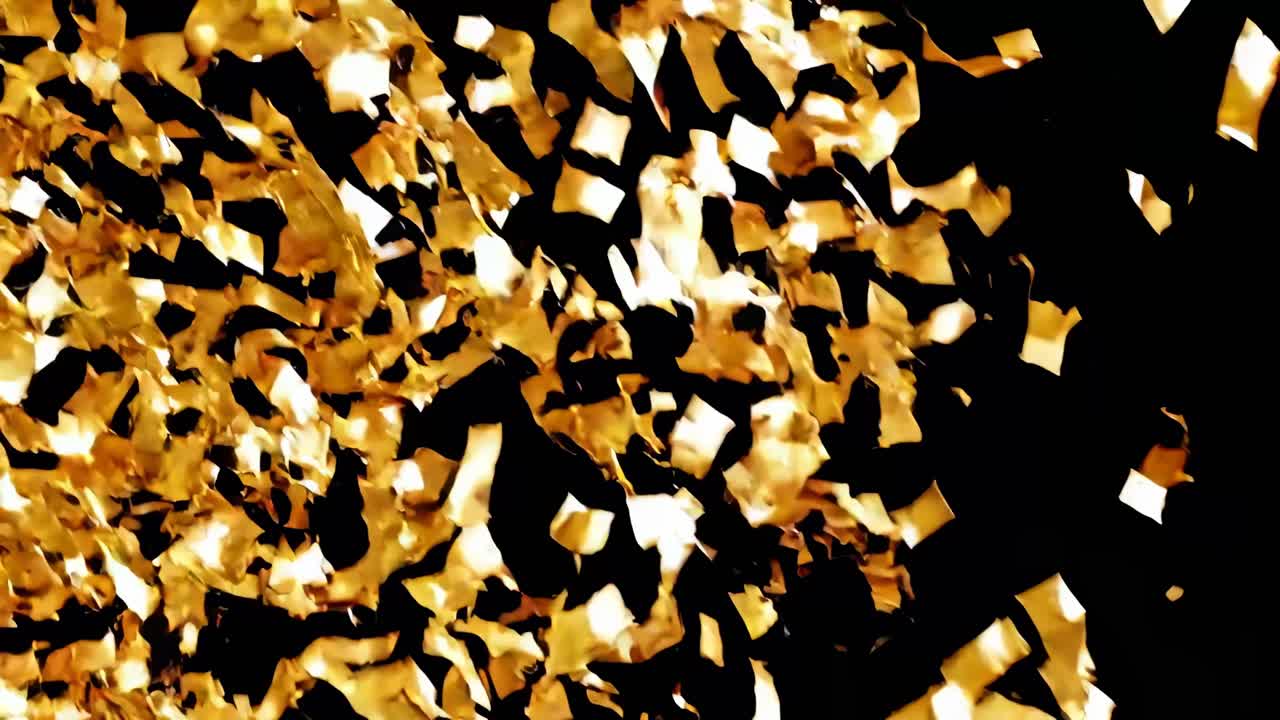 A dynamic video scene capturing golden confetti falling against a black background, shot from a low