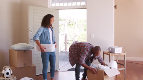 excited family carrying boxes into new home on moving day