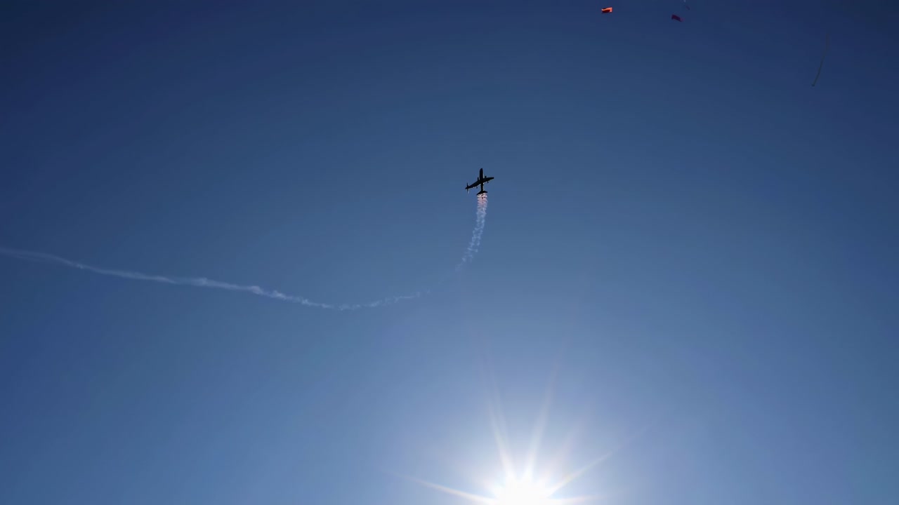 avión de pasajeros atravesando una nube de confeti vibrante contra un cielo azul brillante, simbolizando una celebración festiva y un momento alegre de logro