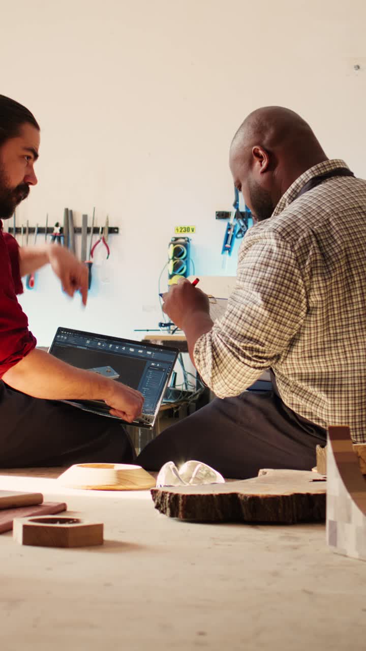 Two Woodworkers Collaborating on Design Plans in a Workshop