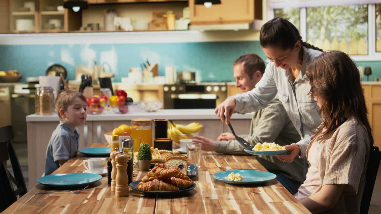Smiling parents and two kids gathered at the breakfast table with waffles