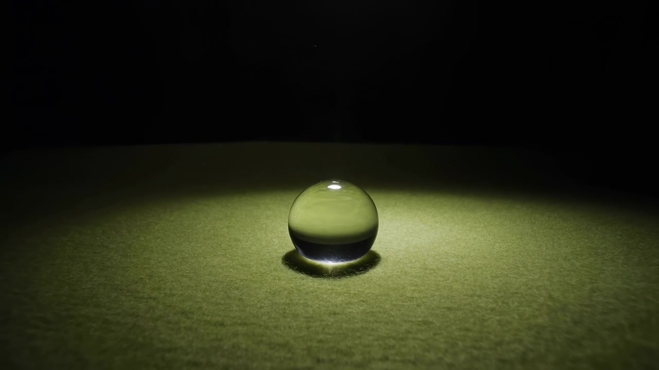 A spherical object no action observed static sequence, in dark background with a light source highlighting the, with spherical object, with glass-like material for the texture, clear detail.