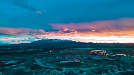colorida puesta de sol sobre las montañas en un suburbio urbano en invierno - hiperlapso aéreo