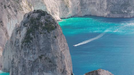 Toma-De-Drone-De-Una-Lancha-Rápida-Navegando-En-El-Mar-Jónico-Bajo-Los-Acantilados-De-La-Isla-De-Zakynthos,-Grecia-50fps