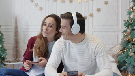 happy couple enjoying music in earphones together.