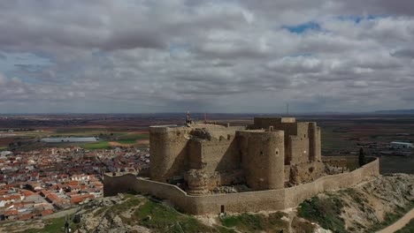 Vuelo-De-Drones-En-Ascenso-Con-Un-Cardán-Girando-Sobre-Un-Castillo-Visitado-Por-Personas-En-Las-Torres-Y-En-El-Patio-De-Armas-Haciendo-Turismo-En-Un-Día-De-Primavera-En-Toledo--España