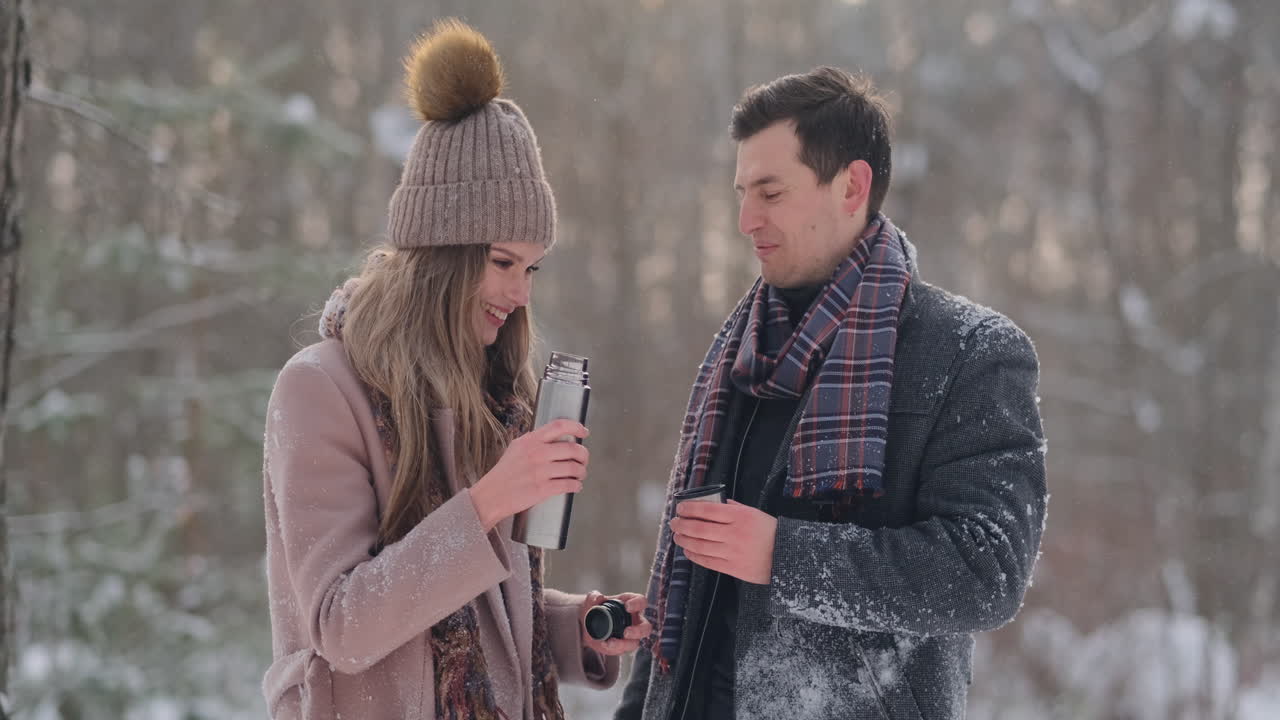 A caring man warms his wife's hands in the winter on the street in a snow-covered Park