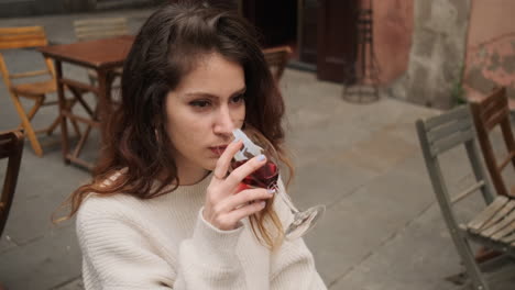 mujer feliz bebiendo vino rojo en una terraza de café
