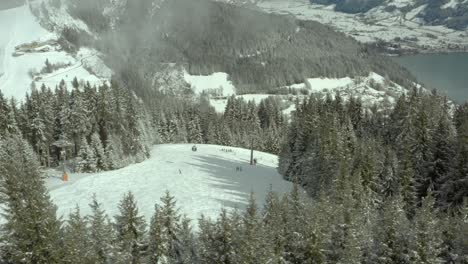 people on winter snow slopes at zell am see ski resort in austria, aerial