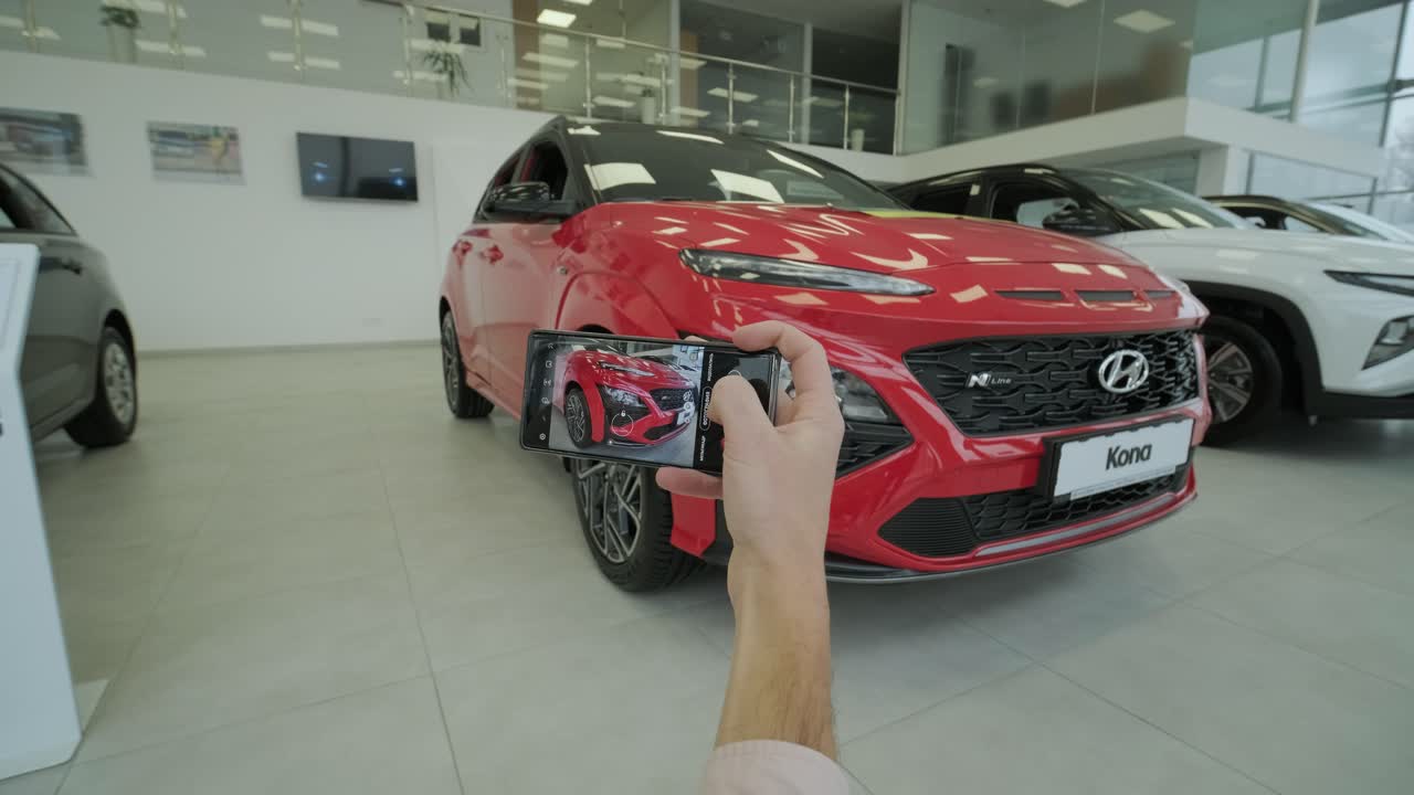 el gerente del concesionario toma fotos de un coche nuevo para la venta. una visión general de los nuevos coches de prestigio en la sala de exposición.