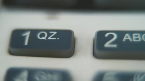 a macro close up shot of a pin pad numbers and letters on colorful buttons, slide right movement, 4k video, depth of field