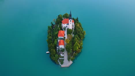 iconic slovenia church is lake island surrounded with water, aerial top down view
