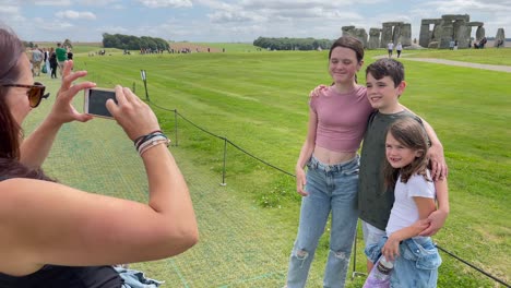 a young family taking a photograph at stonehenge. uk