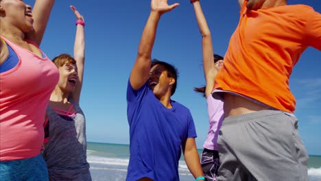 multi ethnic males and females celebrating on beach