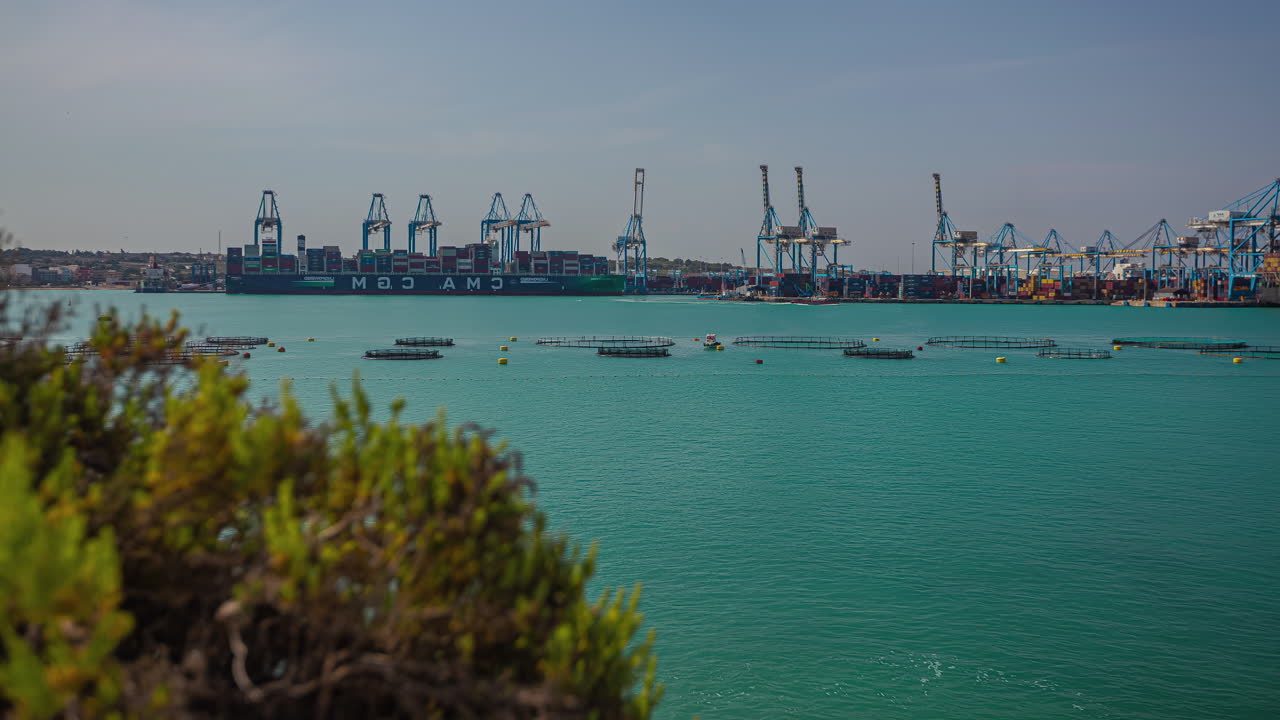 испытайте волшебство увлекательного видения гавани с кранами на фоне захватывающего дух изумрудно-зеленого моря в калафране, мальта