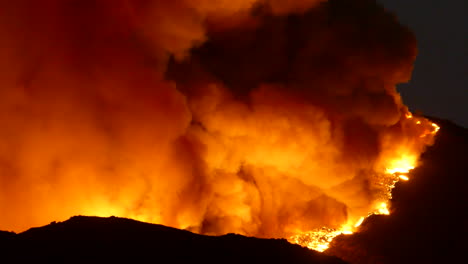 huge billows of black smoke rise into the night sky