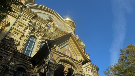 view of orthodox st nicholas naval cathedral golden domes and crosses on blue sky in sunny autumn day at karosta, liepaja, pan right wide shot