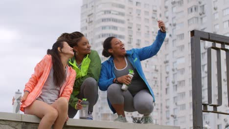 Amigas-Multiétnicas-En-Ropa-Deportiva-Sonriendo-Y-Tomando-Un-Selfie-Durante-El-Descanso-En-Su-Sesión-De-Carrera