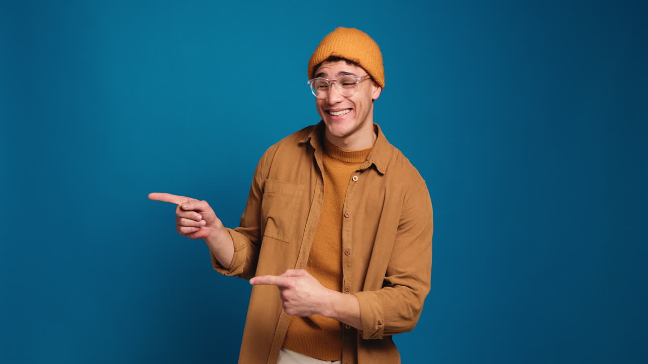 Smiling man in beanie pointing