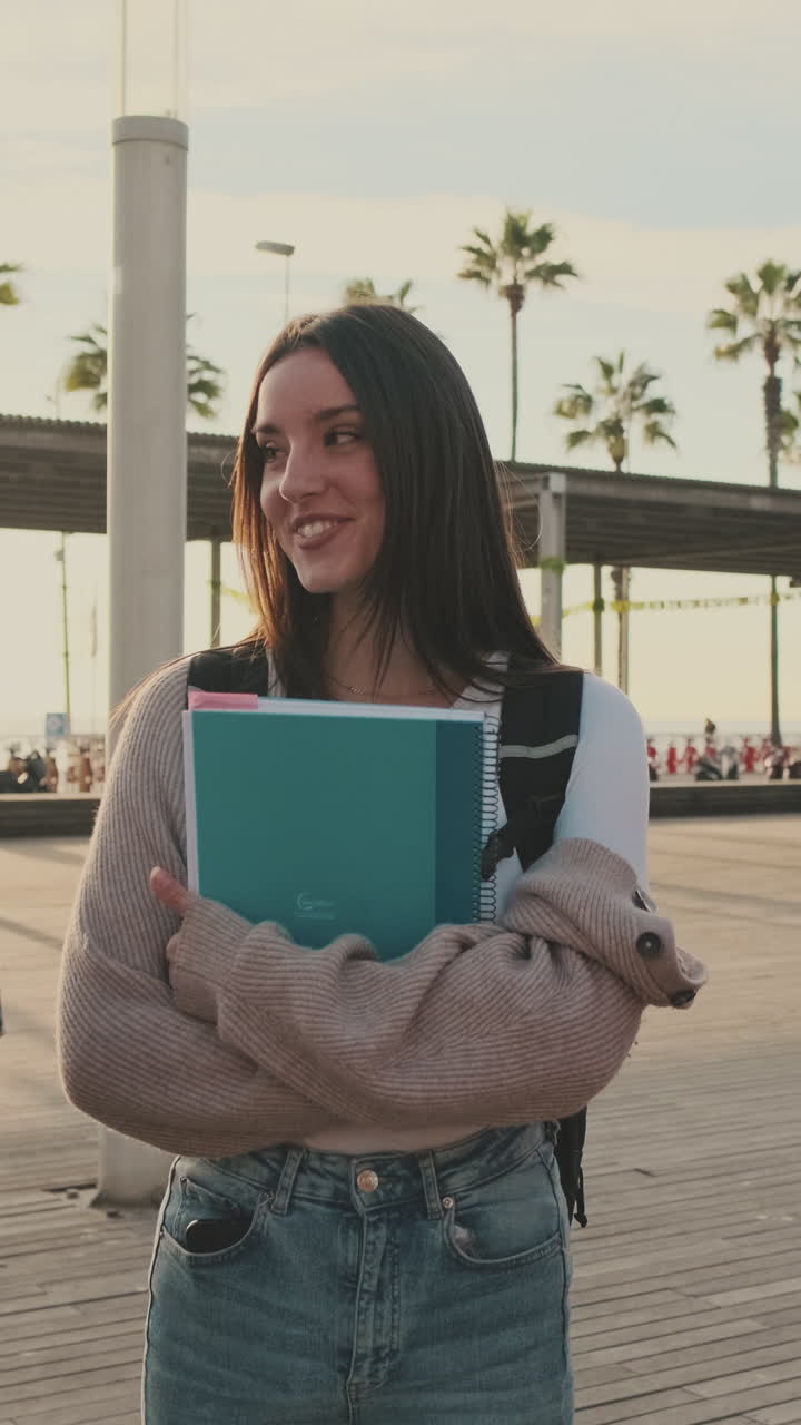 Smiling woman holding notebooks outdoors