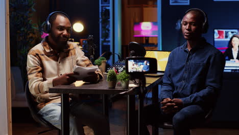 periodista usando equipo de filmación, hablando en el micrófono con un hombre afroamericano