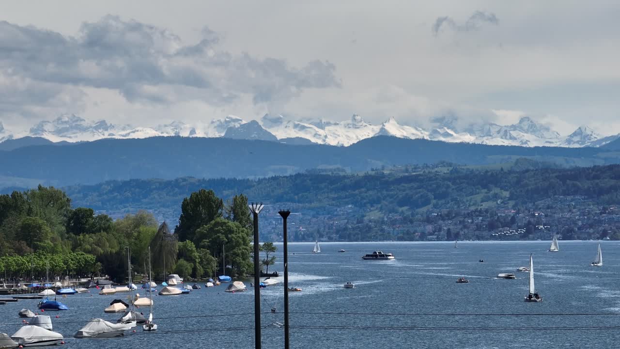 천천히 앞으로 움직이는 드론 으로 리히 호수와 남쪽의 눈 인 스위스 알프스를 멀리서 보여줍니다.