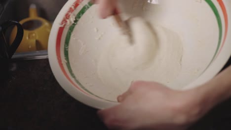 Manual-Method-Of-Mixing-Dough-In-A-Bowl-Using-A-Wooden-Spoon---Closeup-Shot