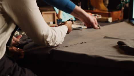 student and old tailor cutting material