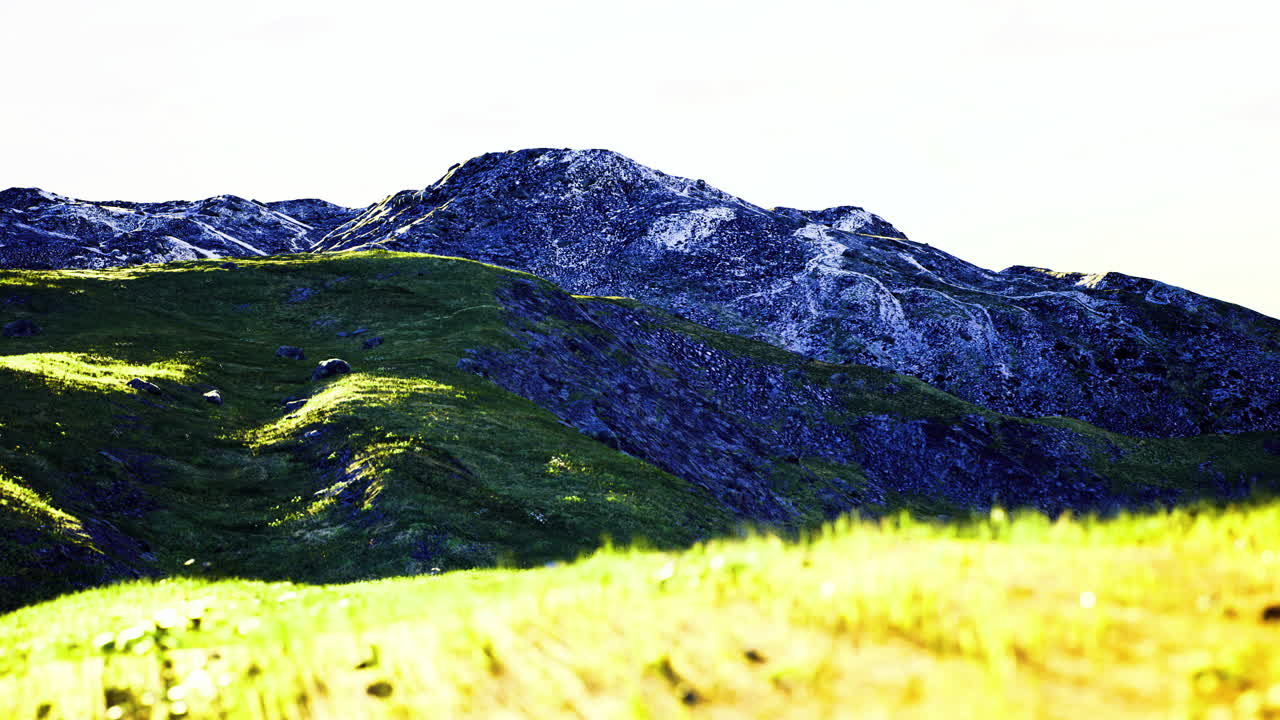 Vibrant green hills under bright skies showcasing rugged mountain beauty